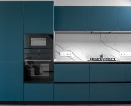 Contemporary kitchen with built-in oven, marble backsplash, and sleek matte blue cabinetry. Functional, stylish and compact cooking zone.